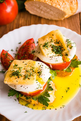 Sandwiches with poached egg, tomato, parsley and cheese.