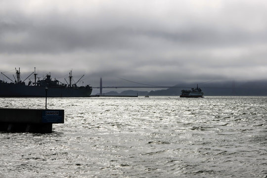  A silhouette image of the Jeramiah O'Brien Liberty Ship and the Golden Gate bridge in San Francisco CA, USA