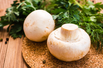 Close-up of fresh champignons and parsley on a wooden table