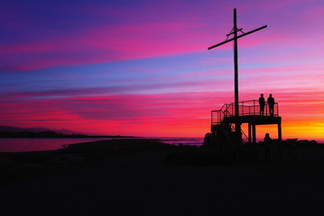 cross  and people silhouttes after sunset