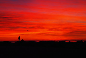 child in front of red sky after sunset
