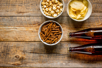 glasses, snacks, beer for whatchig film on wooden background top view space for text