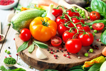 Fresh farm vegetables and herbs on rustic background.