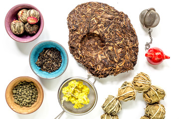 herbs in colorful bowls to make tea on white table background top view pattern