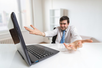 Young confused and unsure man is working with laptop in office.