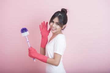 Beautiful asian housewife smiling on pink background