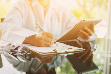 Obraz premium Female doctor prescribes medication. prescription pills are prescribed by doctors,Medical Exam,Healthcare and medically concept,test results with digital tablets ,vintage color,selective focus