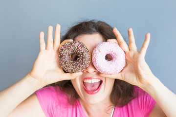 Beauty girl taking colorful donuts. Funny joyful woman with sweets, dessert. Diet, dieting concept....