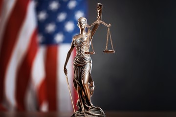 Statue of justice on flag background.