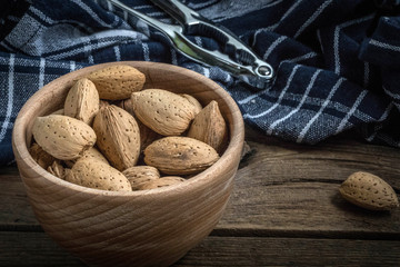 Almonds in-shell in wooden bowl.