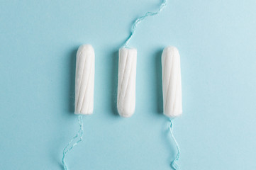 Menstrual tampon on a blue background. Menstruation time. Hygiene and protection - obrazy, fototapety, plakaty