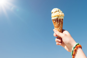 Hand holding ice cream cone on the sky background - 160955053