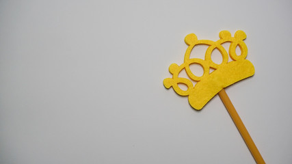 Top or flat lay view of Photo booth props yellow crown on a isolated white background flat lay. Birthday parties and weddings.