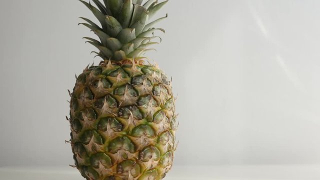 Fresh Ananas comosus tropical fruit 4K 2160p 30fps UltraHD footage - Fresh exotic pineapple on white slow tilt close-up 4K 3840X2160 UHD video 