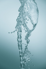 A stream of filtered natural water on a blue background. Splash of mineral drinking water
