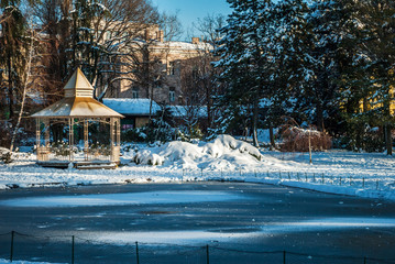 Frozen lake in the  city, with the wooden house by the lake