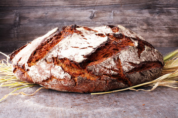 bread and wheat ears on board from above. Kitchen or bakery poster design.