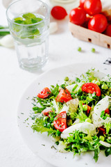 Fresh and healthy fitness salad with lettuce, peas, cherry tomato, cucumber, green onion, dill, sunflower or olive oil and toast on a white background