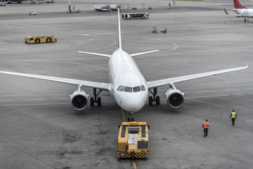 White plane in airport parking.