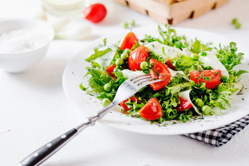 Fresh and healthy fitness salad with lettuce, peas, cherry tomato, cucumber, green onion, dill, sunflower or olive oil and toast on a white background