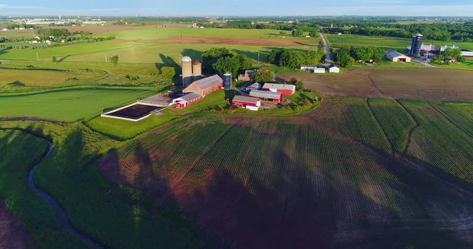 Breathtaking country landscape with fields and farms at daybreak.
