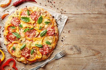 Composition of tasty Italian pizza and spices on wooden table