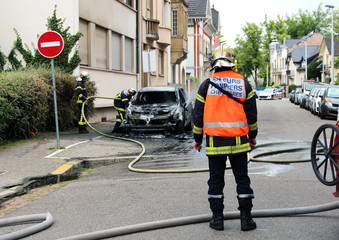Fototapeta premium Burnt out car and firemen