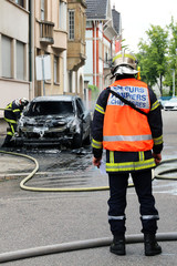 Obraz premium Burnt out car and firemen