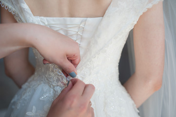 Obraz na płótnie Canvas Fastening the dress, Button fastening on the bride's dress, Bride's fees, Wedding Dress