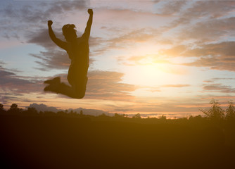 Man in the sunset, happy and jumps.