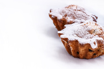 white background with baked muffins in powdered sugar