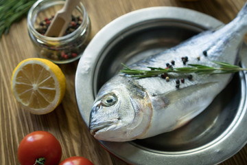 Raw fish cooking and ingredients. Dorado, lemon, herbs and spices.