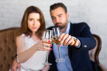 happy couple with glasses of champagne at restaurant
