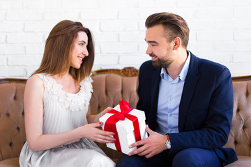 handsome man giving gift box to his girlfriend