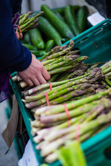 Woman buying fresh asparagus on a market
