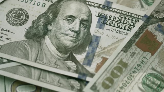 Counting dollars macro. Man carefully counts hundred-dollar bills on the white table.