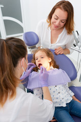 Obraz na płótnie Canvas Dentists making treatment for little girl