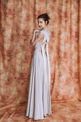 Nice woman with elegant Hairstyle. Brunette Fashion Model Woman wearing Summer Prom long maxi transformer Dress
