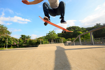young skateboarder legs skateboarding at skatepark