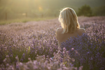 Fototapeta na wymiar Nude woman in lavender field at sunset
