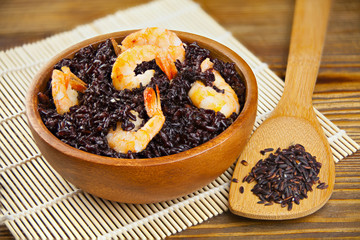 Pilaf with shrimp from wild black rice on table