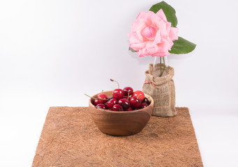Cherries in in wooden bowl and  inspiration words  ,flower o