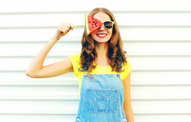 Fashion smiling young woman holding a slice of watermelon in the form of ice cream over a white...