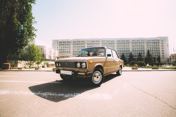 A retro car made in the USSR stands on the background of Kiev Polytechnic Institute. Kiev, Ukraine.