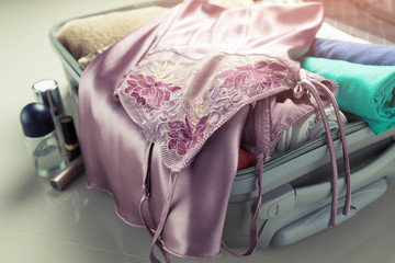 Close up of businesswoman packing clothes into travel bag - Luggage and people concept