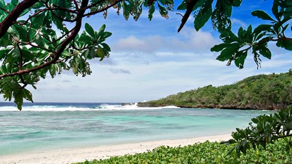 Leaves from a tree frames a portion of the Wing Beach in Saipan, Northern Mariana Islands.