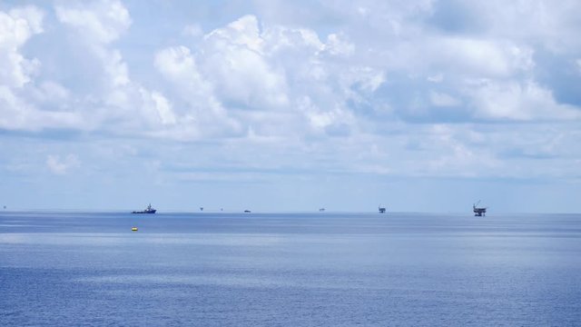 Small offshore platform and crew boat in the middle of the ocean 
