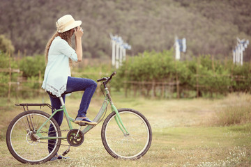 Asian woman on bicycle taking photo