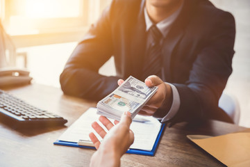Businessman giving money to his partner while making contract