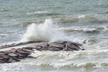 Obraz premium Rough surf breaking over jetty